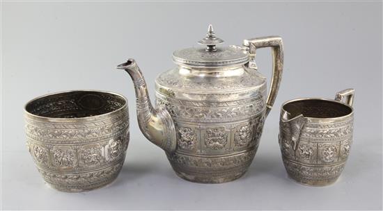 A late Victorian Scottish Indian style silver three piece tea set by James Reid & Co, gross 35 oz.